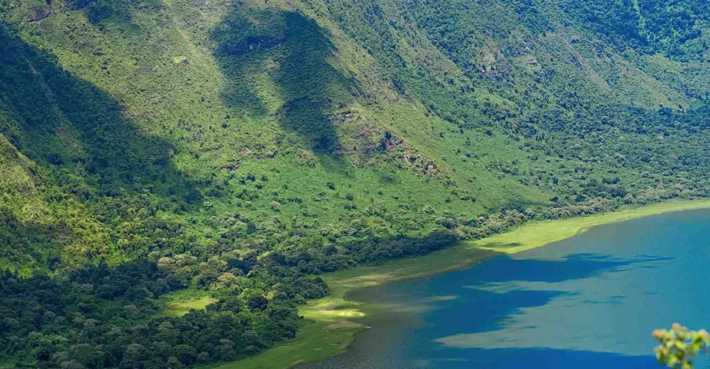 Empakai Crater's lake seen from the rim, ringed by steep green walls