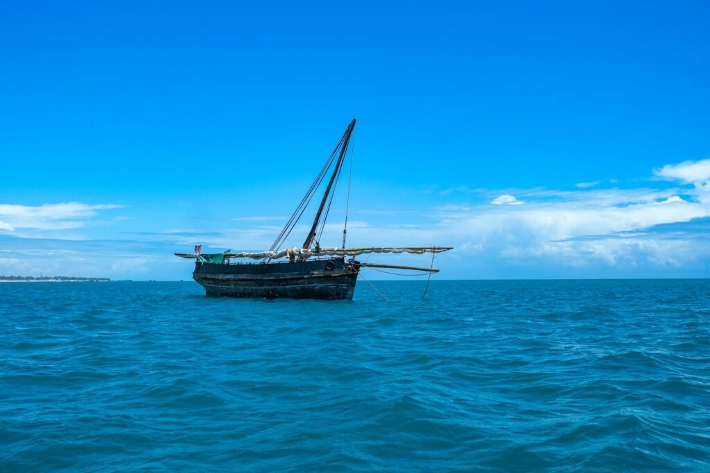 A wooden dhow at anchor with its sail furled on the blue Indian Ocean off the Tanzanian coast